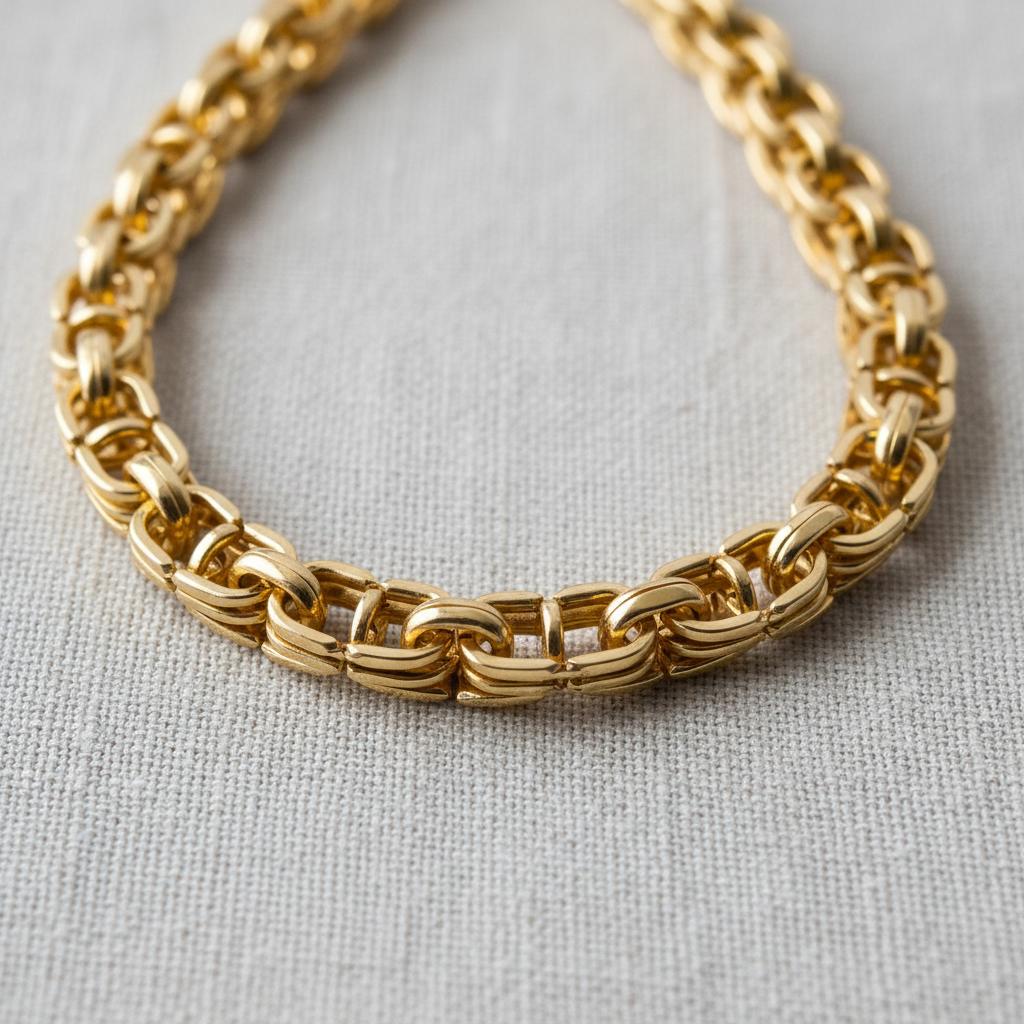 Gold pendant necklace close-up on bright white surface showing intricate chain link craftsmanship