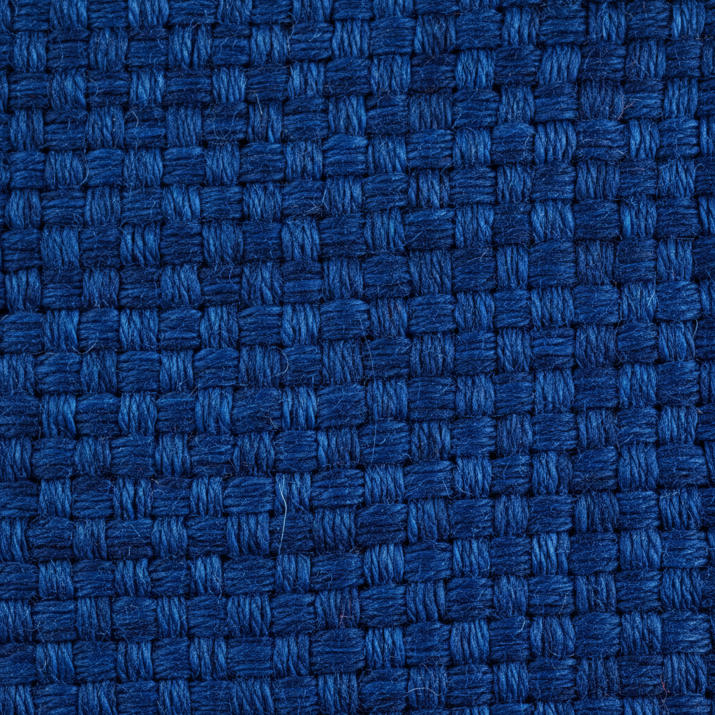 Macro photograph of hand-dyed indigo silk textile showing deep blue pigment pooling in woven fibers