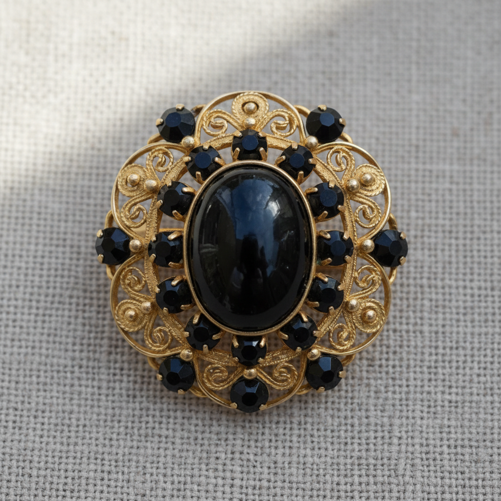 Victorian mourning brooch with jet black stones and gold filigree detail