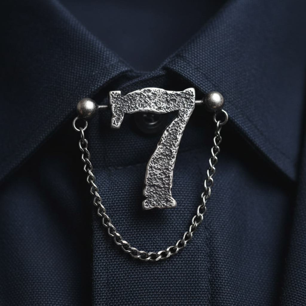Oxidised silver collar pin number seven design on dark fabric collar