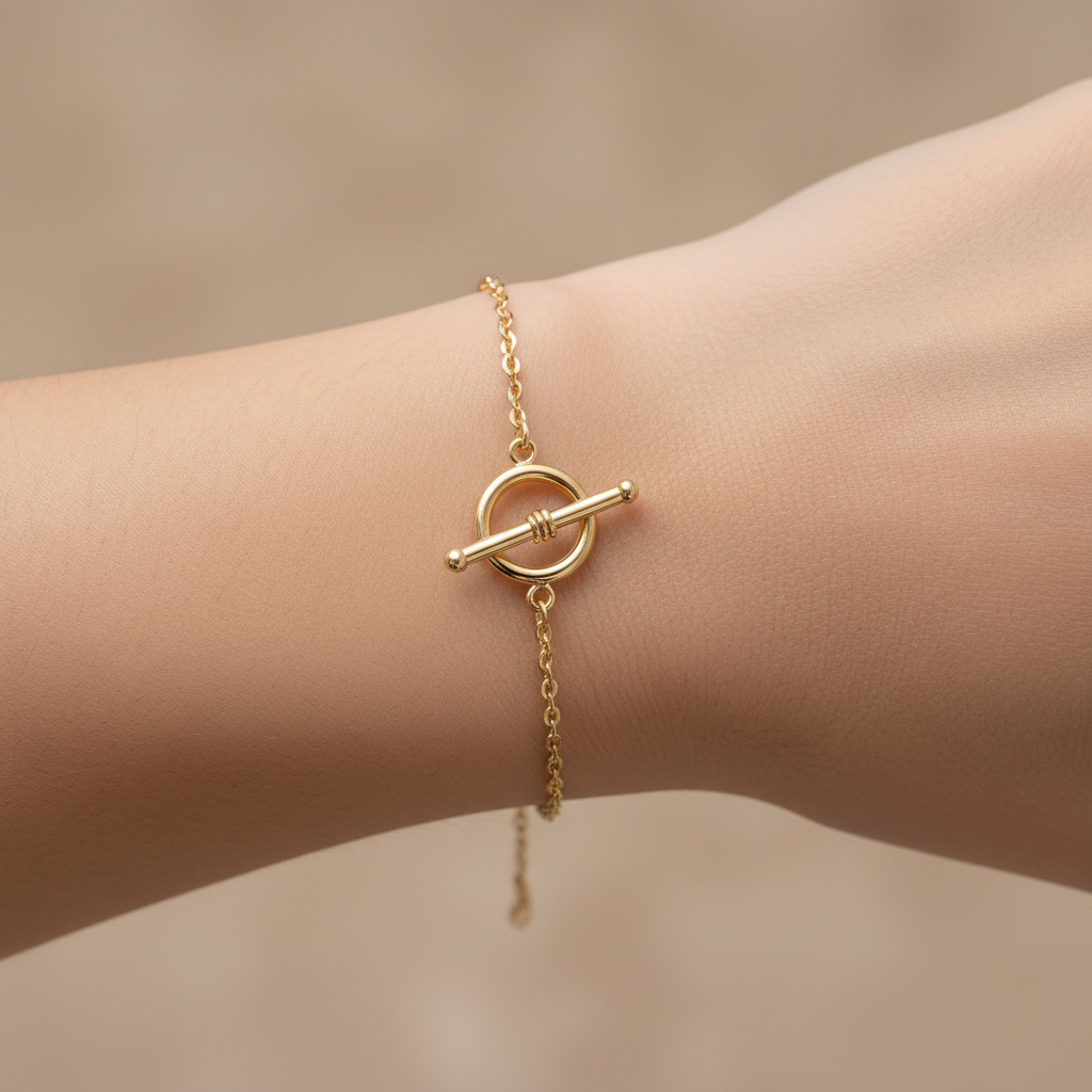 Dainty gold chain bracelet with toggle clasp on wrist, soft focus
